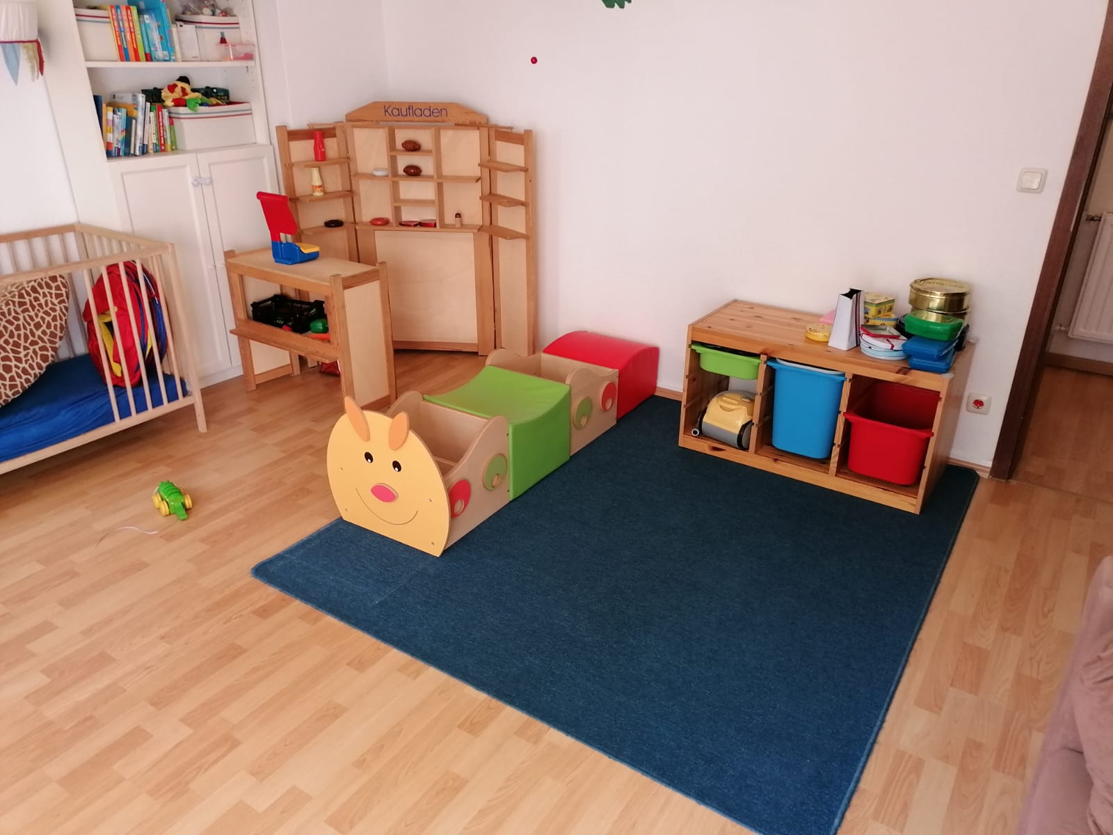 Spielecke mit Kaufladen, Teppich und Holzspielzeug