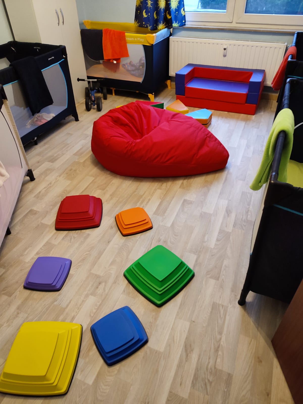 Spielzimmer mit rotem Sitzsack und bunten Balancier-Kissen